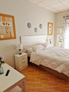 科尔多瓦Hostal El Brillante - Alojamientos El Duque的卧室配有白色的床、桌子和书桌