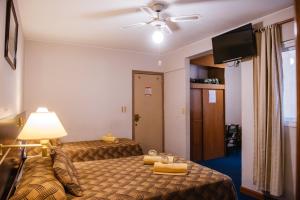 门多萨Hotel Pacífico的酒店客房配有两张床和吊扇。