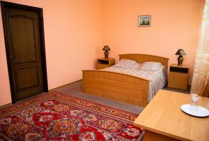 克列缅丘格Avalon的一间卧室配有一张床、一张桌子和一张地毯。