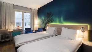 波多索恩诺德里斯酒店的配有极光的酒店客房内的两张床