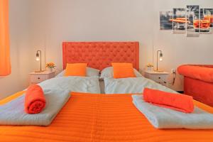 兹诺伊莫Rezidence Znojmo的一间卧室配有两张带橙色枕头的床。