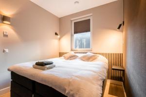 坎珀兰Luxe appartement in haven Marina Kamperland - 2 badkamers的一间卧室设有一张大床和窗户