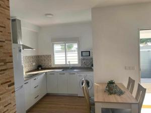 加的斯Villa Zen, La Barrosa的厨房配有白色橱柜和木桌