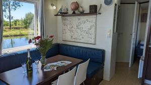 圣让德洛讷Cottage flottant jacuzzi privé en option gamme supérieure的一间带桌子和蓝色沙发的用餐室