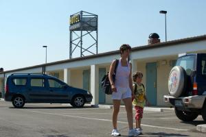 拉文纳Autohotel Ravenna的站在停车场的女人和孩子