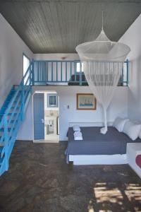 圣乔治亚海滩Oliaros seaside complex的一间卧室设有一张床和一个蓝色的楼梯