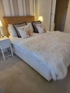 InverkipLanghouse Castle Bed and Breakfast的一张带白色棉被和枕头的床