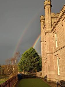 InverkipLanghouse Castle Bed and Breakfast的城堡后面的天上的彩虹