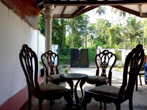 本托塔Indra Sisila Villa Bentota的庭院里设有三把椅子和一张桌子