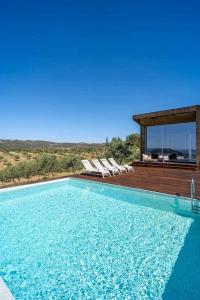 LodõesAcushla Golden House Douro的一个带躺椅的游泳池以及一座房子