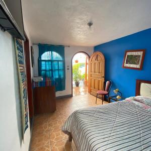 奥塔瓦洛Hostal Chasqui的一间卧室设有一张床和蓝色的墙壁
