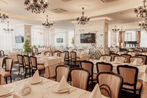 喀山Olymp Kazan的宴会厅配有桌椅和吊灯。