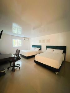 圣安德烈斯Apartahotel Plaza的一间卧室配有两张床、一张桌子和一架钢琴
