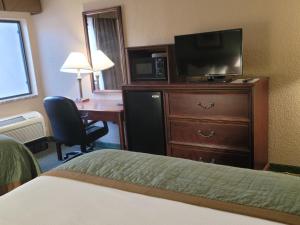 切罗基Bay Mountain Inn Cherokee Smoky Mountains的酒店客房配有一张床、一台电视和一张书桌。