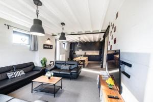 HeersDE SMISHOEVE 4 vakantiewoningen met speelruimte, dieren en wellness的客厅配有沙发和桌子