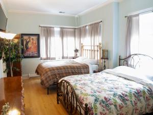 芝加哥Bootlegger House Sleeps 10-20 Free TV & Parking的一间卧室设有两张床和窗户。
