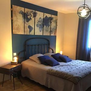 卡尔卡松L’Antre d’Eux的卧室配有一张大床,墙上挂有绘画作品