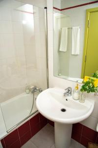 赫塔费Hotel La Parada的白色的浴室设有水槽、浴缸和镜子