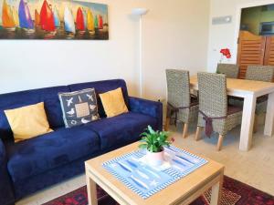 佩罗斯-吉雷克Appartement Perros-Guirec, 2 pièces, 2 personnes - FR-1-368-219的客厅配有蓝色的沙发和桌子