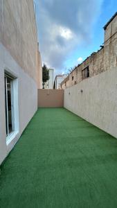 阿哈达فيلا قمرية الهدا的一座空洞的庭院,在建筑里种着绿草