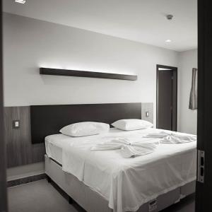 Boa EsperançaHOTEL BRASIL的卧室配有一张带白色床单和枕头的大床。