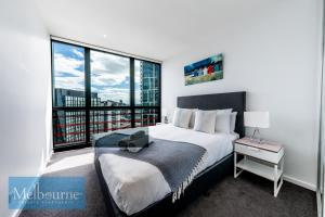 墨尔本墨尔本私人公寓 - 滨海港区科林斯街的一间卧室设有一张大床和一个大窗户