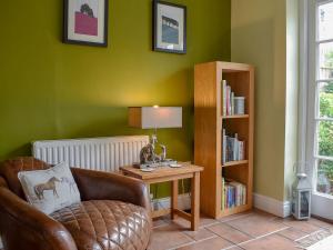 伯利Mast Cottage的客厅配有椅子和带台灯的桌子