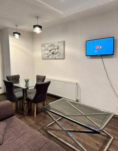 伦敦Alarabi Apartments-Peckham的客厅配有玻璃桌和椅子