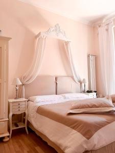 罗马拉斯提弗列丽城住宿加早餐旅馆的白色卧室设有一张带天蓬的大床