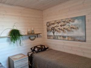 KäinaKuusekoda的卧室配有一张床,墙上挂有绘画作品