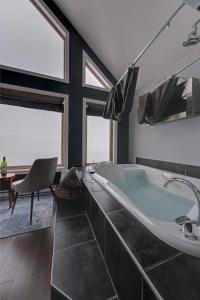 科纳布鲁克Coastal Lookout Suites的带浴缸、椅子和窗户的浴室