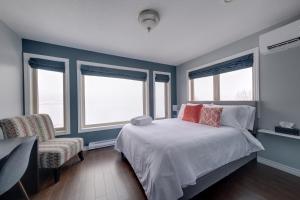 科纳布鲁克Coastal Lookout Suites的卧室拥有蓝色的墙壁,配有一张床和椅子