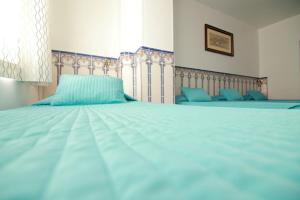 里斯本若昂酒店的一张配有蓝色床单的大床和窗户