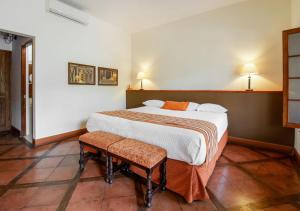 上钦查卡萨哈斯恩达桑吉斯酒店的一间卧室配有一张大床和两把椅子