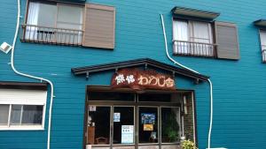 五岛Ryokan Warajisha - Vacation STAY 62566v的蓝色的建筑,上面有狗的标志