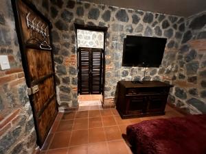 危地马拉安地瓜Villas Gasconia的一间石墙配有电视的房间
