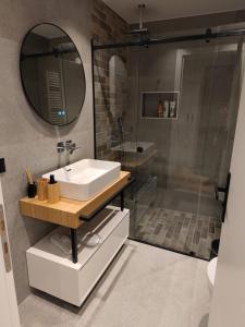 雅典A&N Athens Luxury Apartments - Ermou的浴室配有盥洗盆和带镜子的淋浴