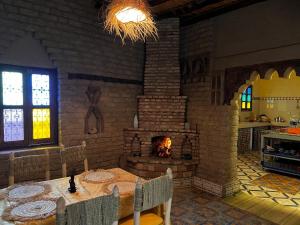 RissaniDar Haroun的一间带桌子和壁炉的用餐室