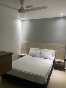 莱蒂西亚Hotel River Suite的一间卧室配有一张带白色床单和天花板的床。