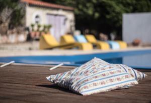 菲盖拉-达福什Casa na Floresta的游泳池畔的桌子上的一个枕头