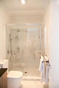 KeswickHilton Executive Apartments的带淋浴和卫生间的白色浴室