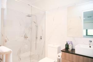 KeswickHilton Executive Apartments的带淋浴和盥洗盆的白色浴室