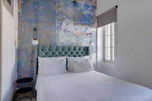 埃尔莫波利斯The Ten Syros的一间卧室配有一张白色的床和蓝色床头板