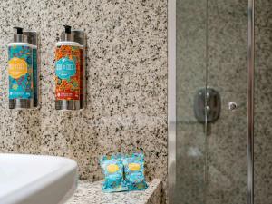 瓜鲁柳斯圣保罗瓜鲁柳斯机场铂尔曼酒店的浴室提供2瓶肥皂和淋浴。
