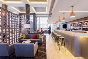悉尼悉尼机场旅客之家酒店的大厅配有沙发,大楼内设有一间酒吧