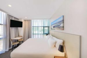 悉尼悉尼机场旅客之家酒店的酒店客房设有一张大床和一台电视机。