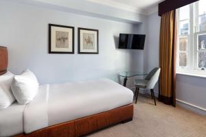 伦敦Radisson Blu Hotel, London Bond Street的酒店客房设有床、桌子和窗户。