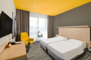 布达佩斯布达佩斯丽笙布鲁酒店的酒店客房设有两张床和一台平面电视。
