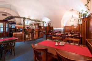 赫拉德茨 - 克拉洛韦诺维阿达波提姆酒店的一间带桌椅的餐厅和一间酒吧