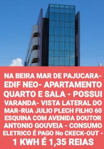 马塞约NA BEIRA MAR DE PAJUCARA- EDIF NEO- APARTAMENTO QUARTO E SALA - POSSUI VARANDA- VISTA LATERAL DO MAR-RUA JULIO PLECH FILHO 60 ESQUINA COM AVENIDA DOUTOR ANTONIO GOUVEIA - CONSUMO ELETRICO É PAGO No CKECK-OUT - 1 KWH É 1,35 REIAS的一座高楼前的大标志